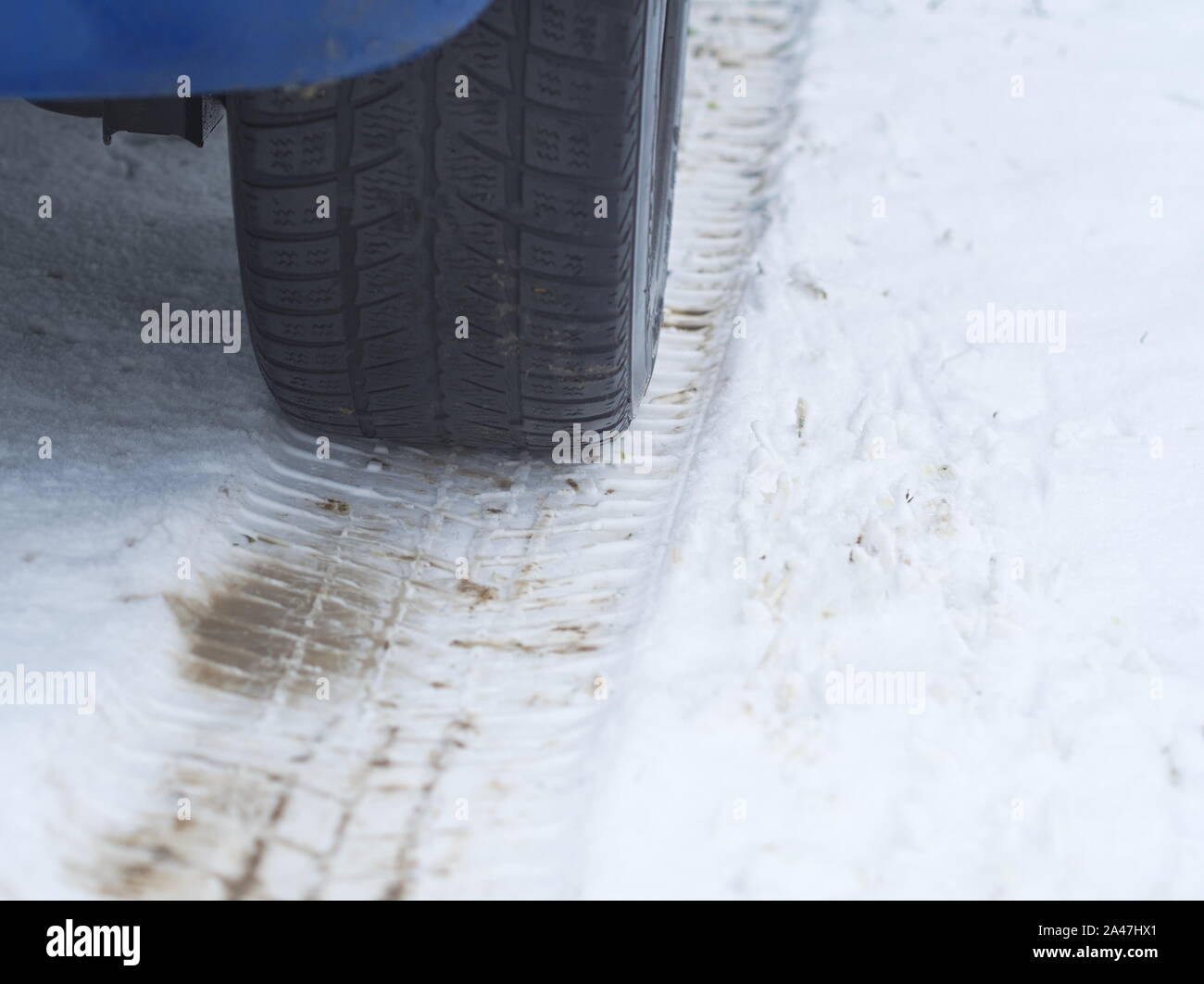 Car Tire on a Snowy Winter Road Closeup Stock Photo