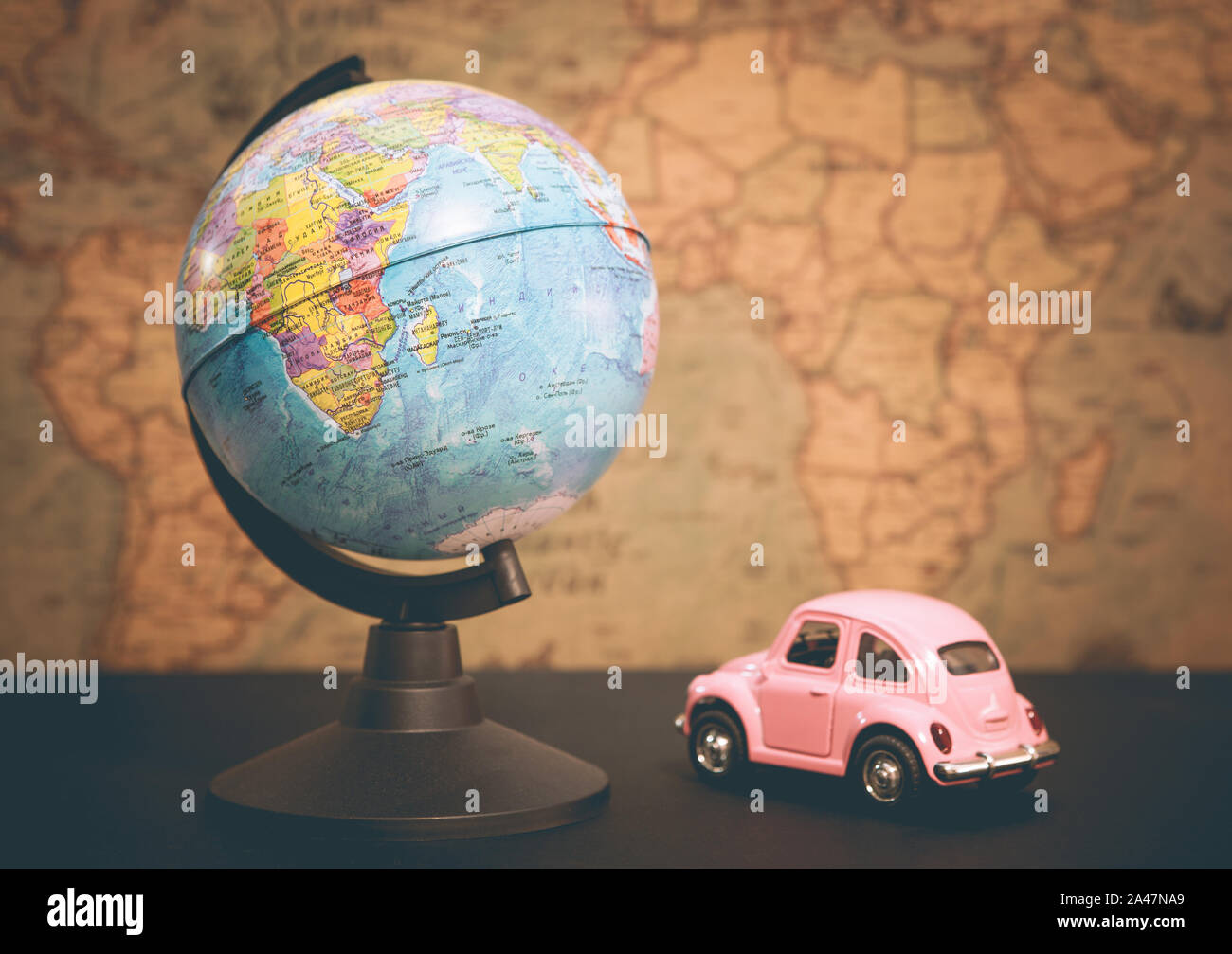 Vintage pink car and globe on a map background Stock Photo