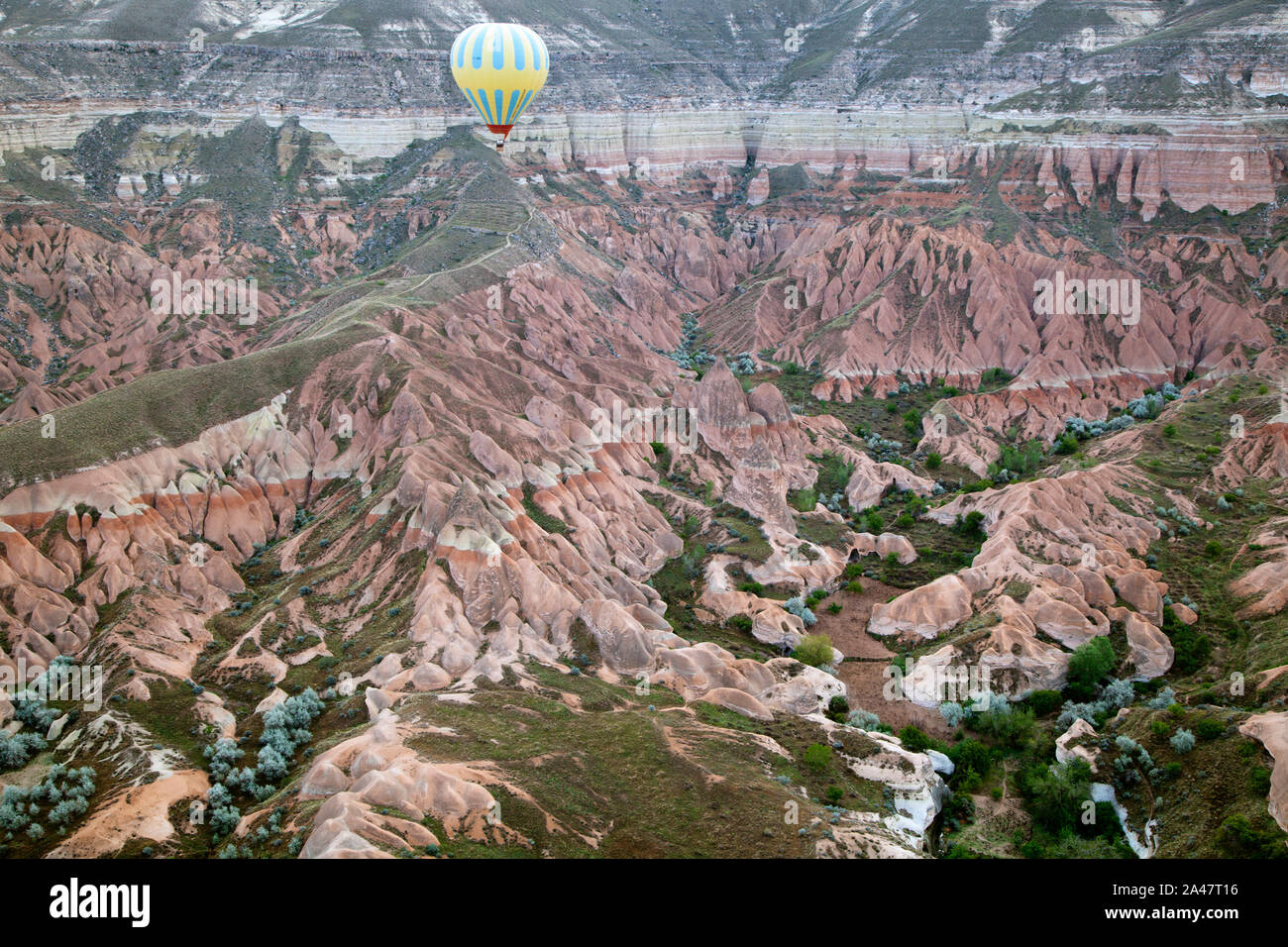 View of the air balloon flying over rock formation in Cappadocia,Turkey Stock Photo