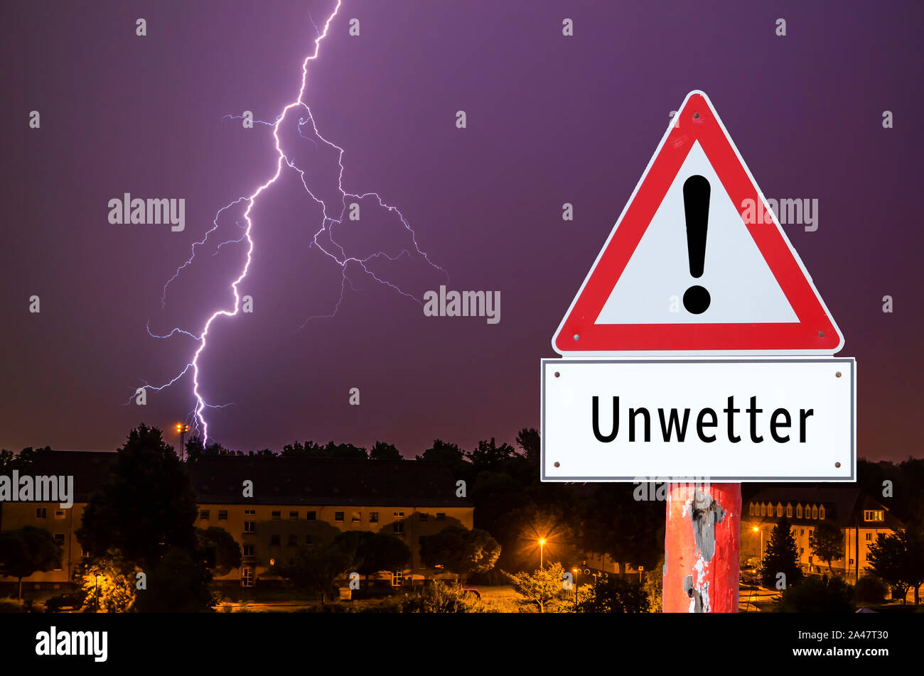 lightning storm in the evening with city lights german warning sign Stock Photo