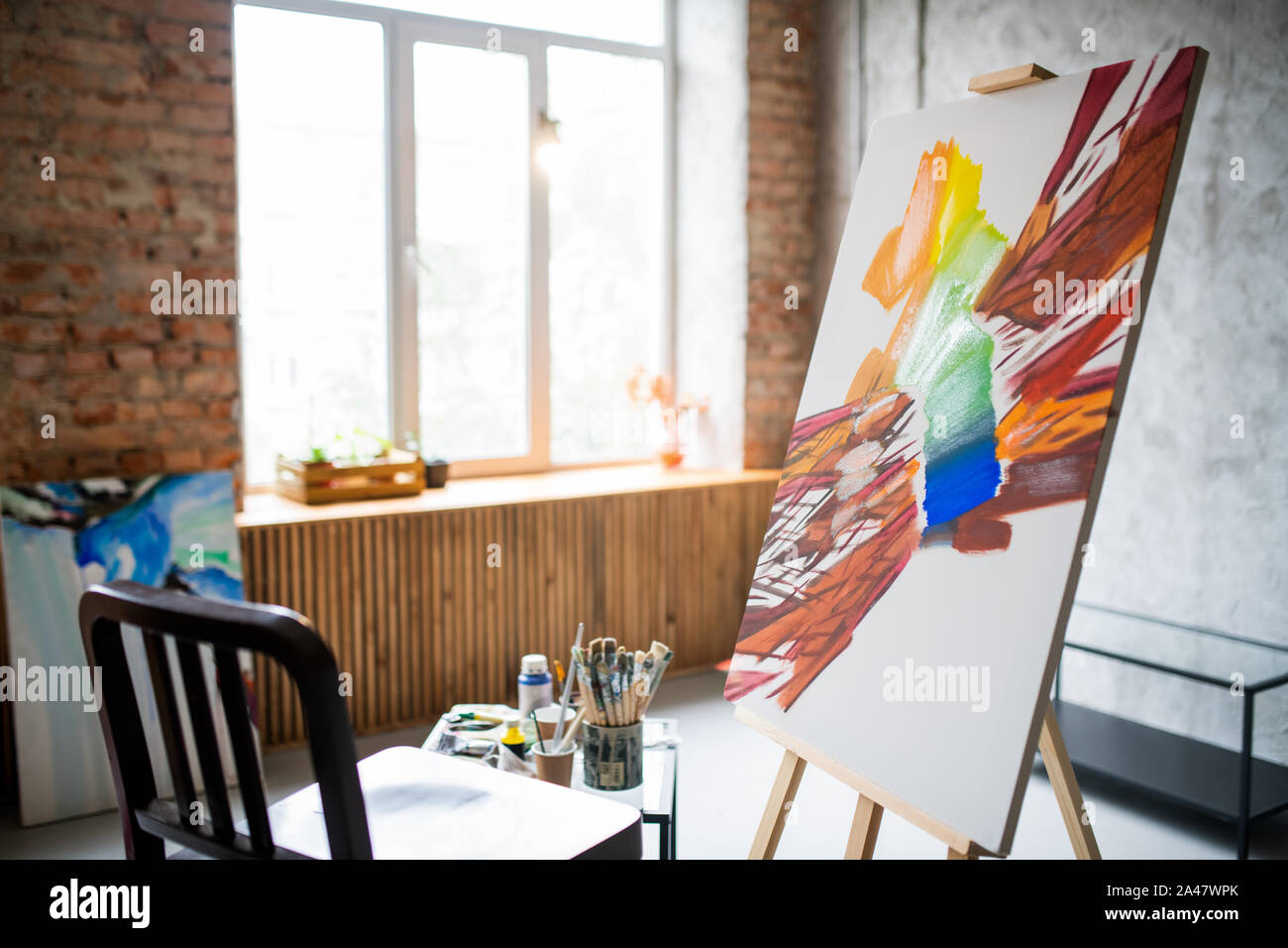 Unfinished abstract painting on easel with wooden chair in front in studio Stock Photo Alamy
