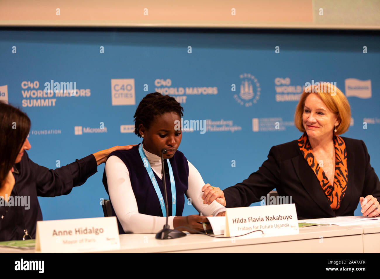 COPENHAGEN, DENMARK – OCTOBER 11, 2019: Hilda Flavia Nakabuye, climate activists within the ‘Fridays for Future’ movement,  Uganda, during the ‘Mayors and Youth Activist’ press conference at the C40 World Mayors Summit. The young activist from Uganda gave a powerful and emotional speech and is here supported by Yvonne Aki-Sawyer (R), Mayor of Freetown, Seattle, and Anne Hidalgo, Mayor of Paris.  During the press conference young activist explained what they expect of the grown-up politicians. More than 90 mayors of some of the world’s largest and most influential cities representing some 700 m Stock Photo