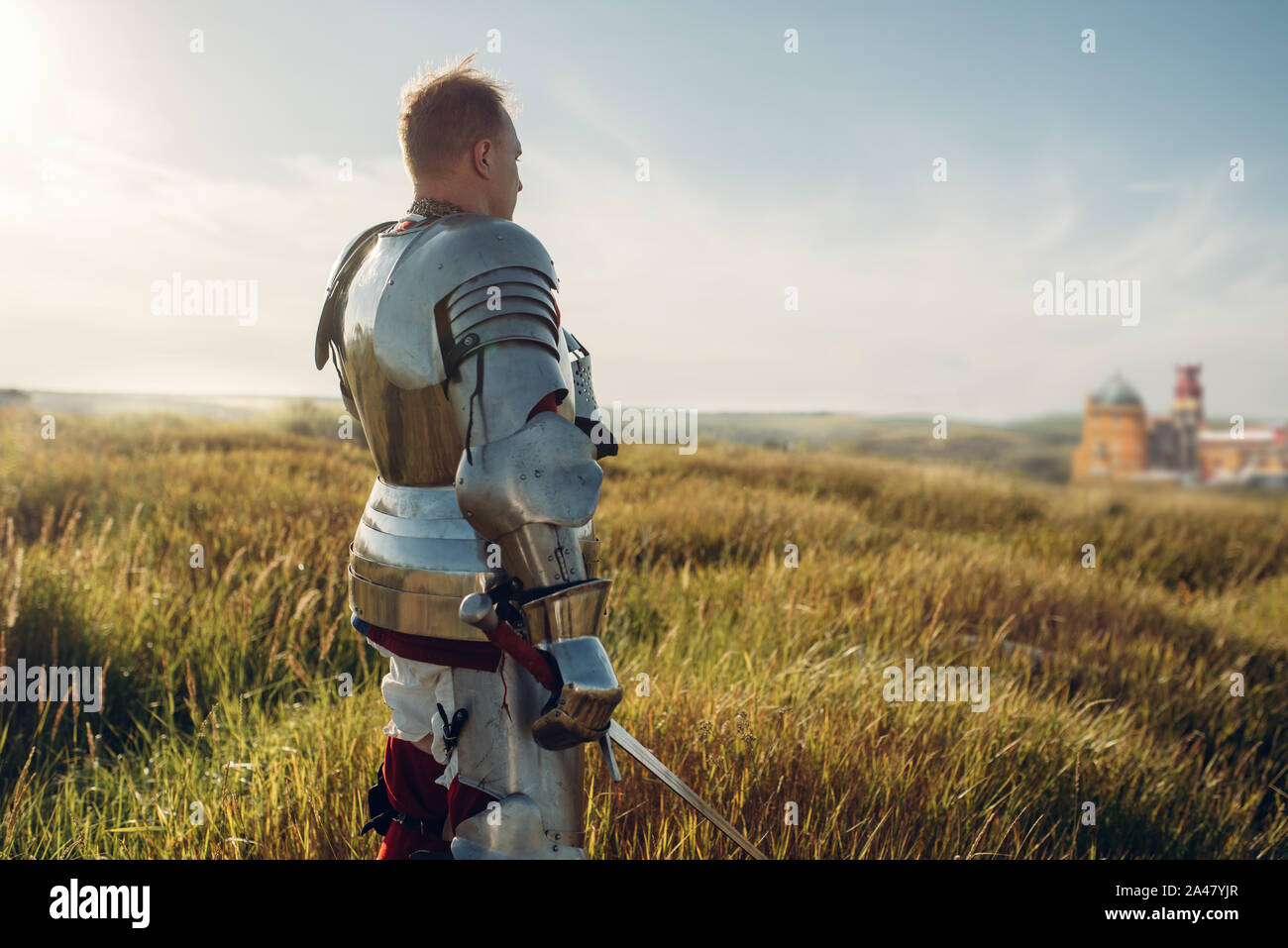 Medieval knight in armor holds sword Stock Photo - Alamy