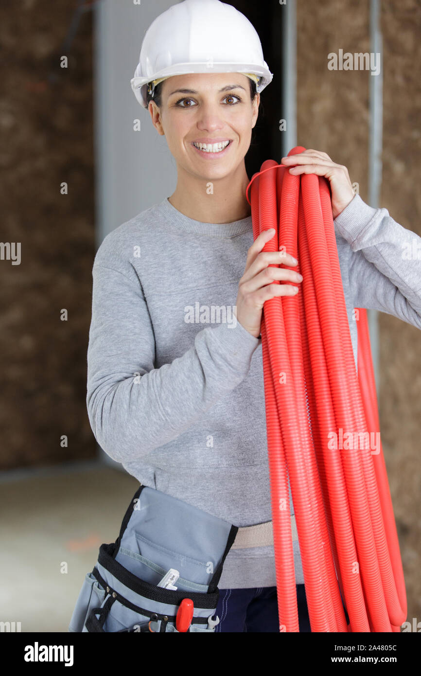 female worker holding pipes in a construction site Stock Photo - Alamy