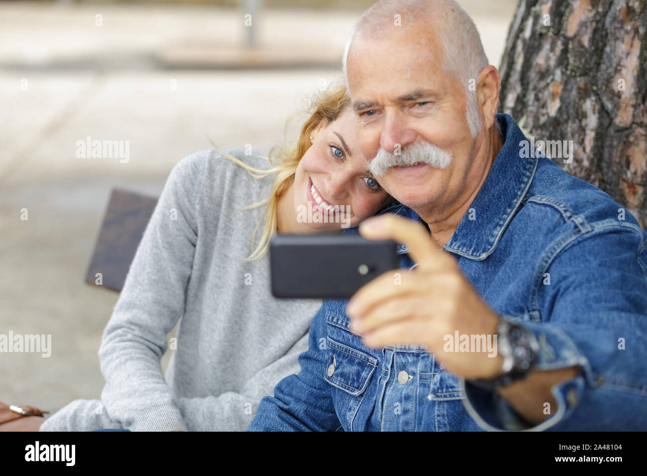 girl taking selfie with her grandad Stock Photo