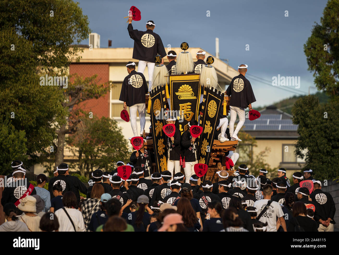 Local leaders atop wooden cart amid crowd at Japanese danjiri festival Stock Photo