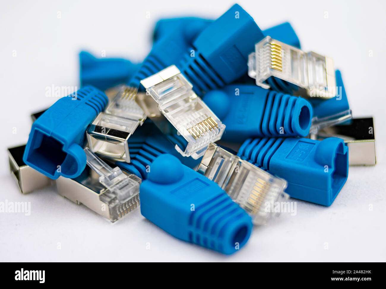 Parts of an RJ45 connector or network cable with gold pins and blue shield with metal insulator Stock Photo