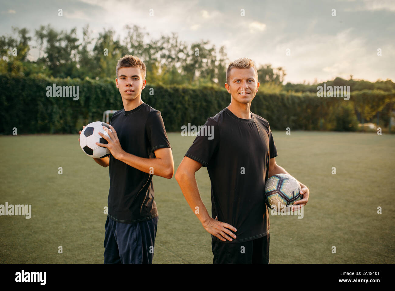 Two male soccer players holding balls in hands Stock Photo