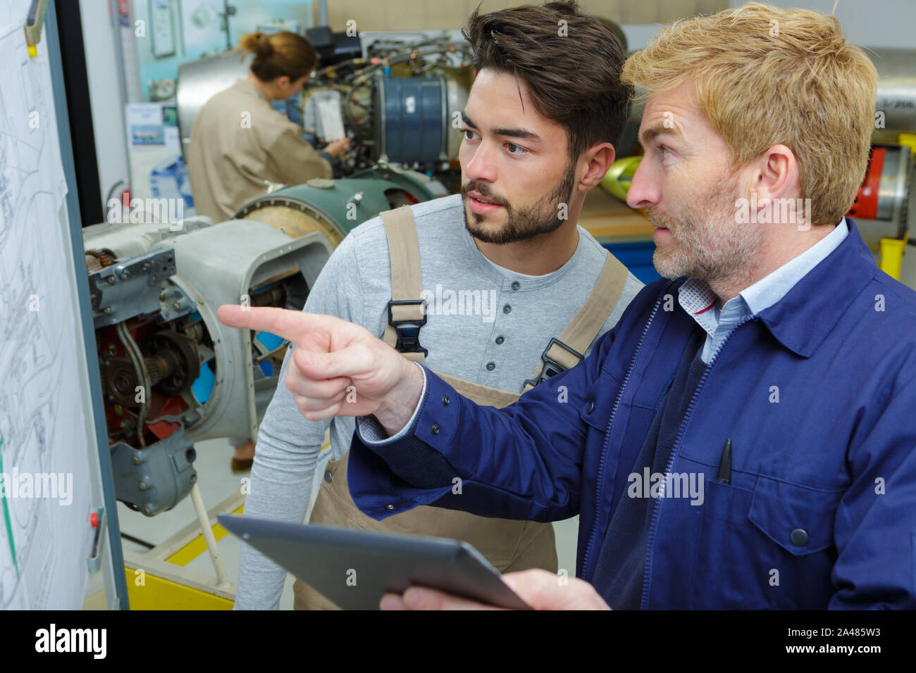 portrait of two factory workers operating modern equipment Stock Photo ...