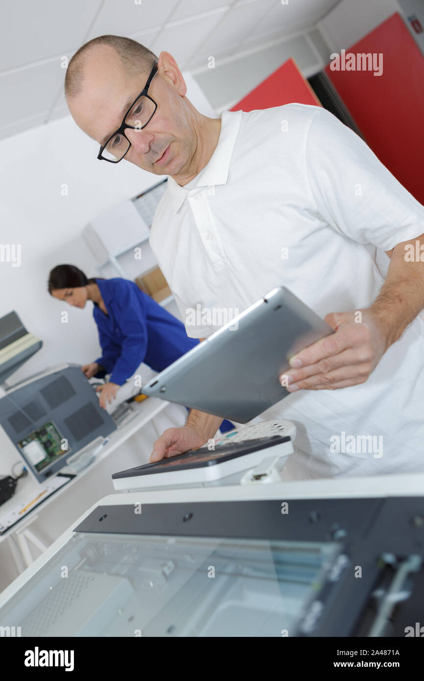 man reading instruction for 3d printer on tablet computer Stock Photo