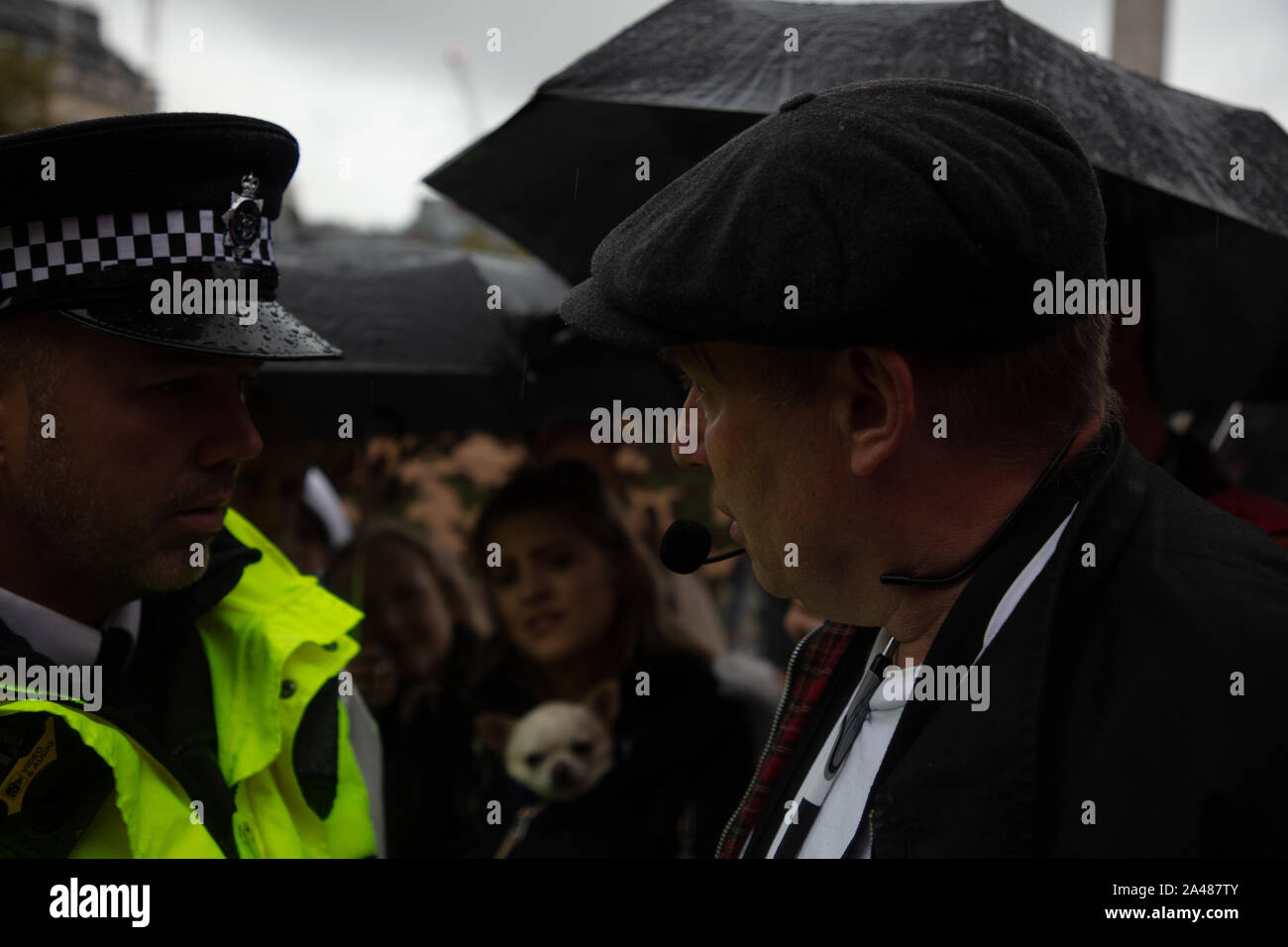 London, UK. 12th October 2019. Police officer seen having a word with an anti-extinction rebellion protester on Trafalgar Square,  during the Extinction Rebellion two week long protest in London. Credit: Joe Kuis / Alamy News Stock Photo