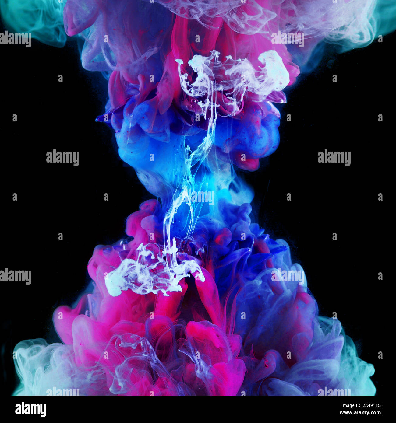 Explosion of color, concept. Splashes of colored ink in water, bright colors. Creative and color mix, abstract swirls of different colors on a black. Stock Photo