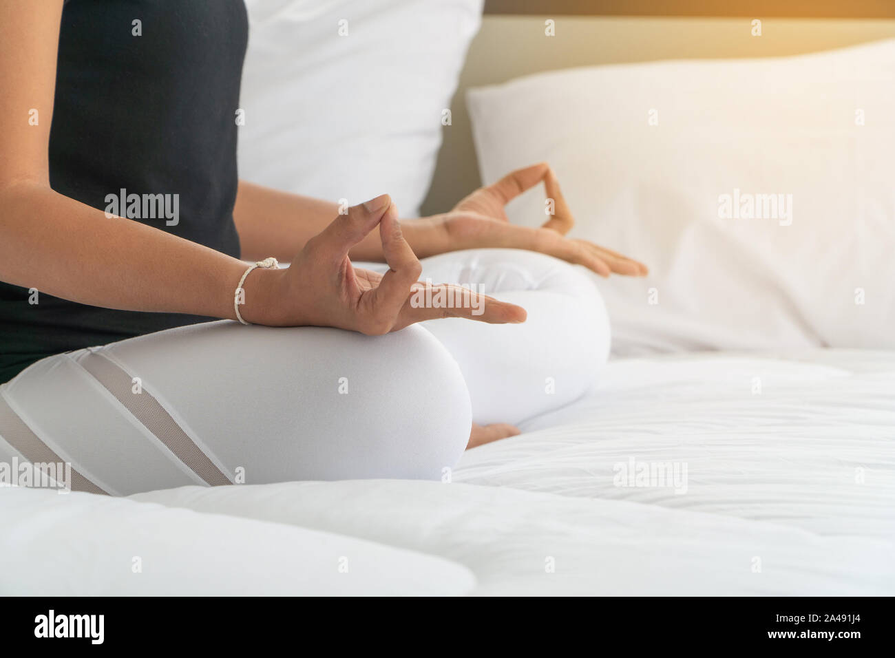 Middle aged women doing yoga easy pose to meditation with yoga in bedroom at the morning, adho mukha svanasana pose. Concept of exercise and relaxatio Stock Photo