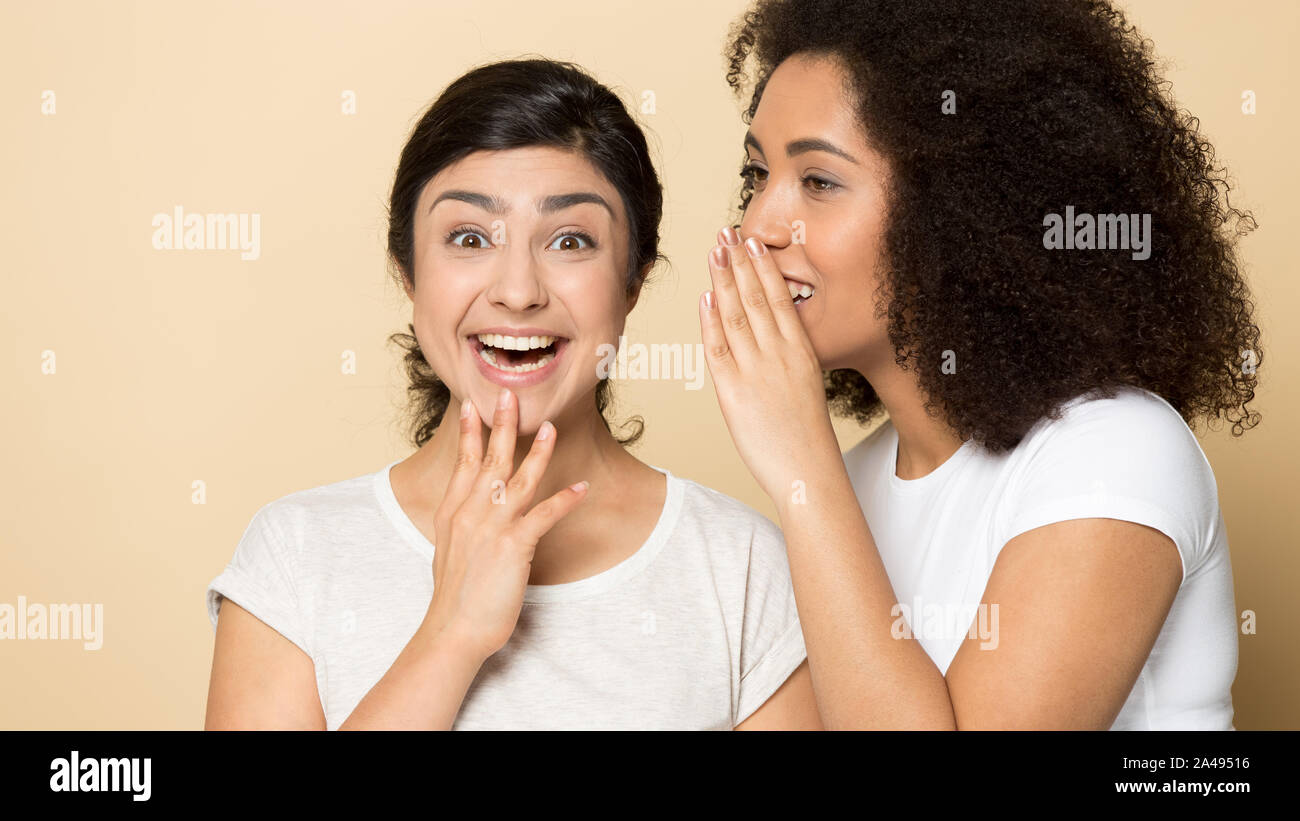 Happy multiethnic millennial girlfriends gossip share secrets Stock Photo