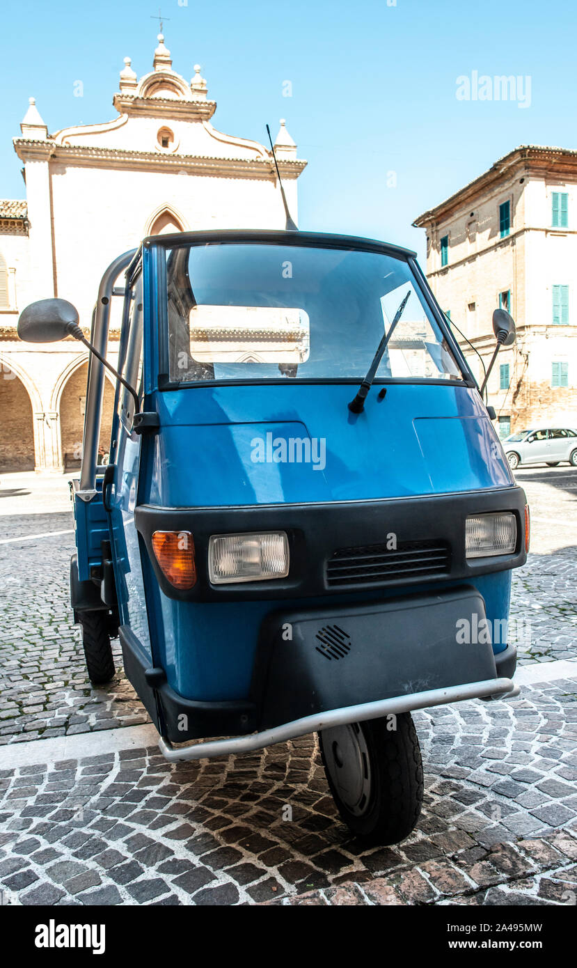 Typical italian farm truck on three wheels. Parked in ancient italian square. Stock Photo