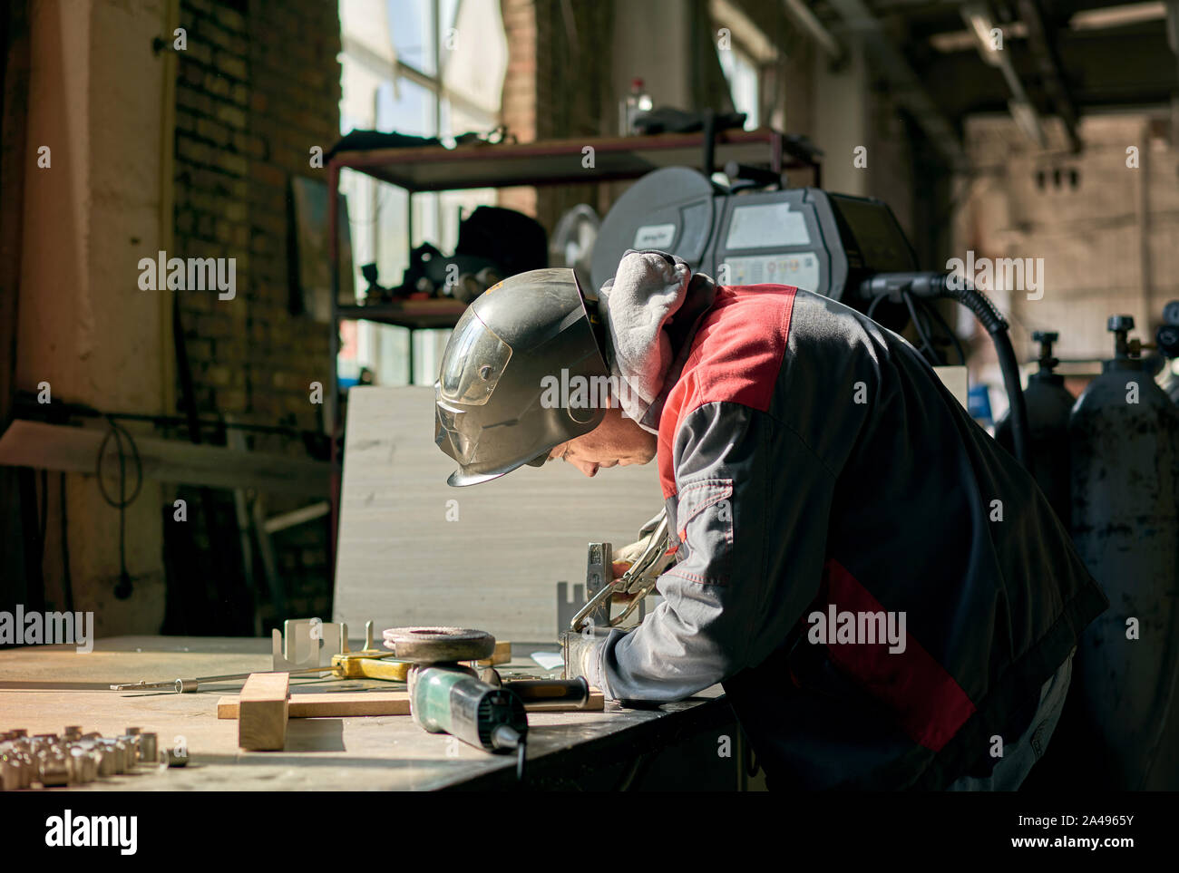 man in overalls working with welding Stock Photo