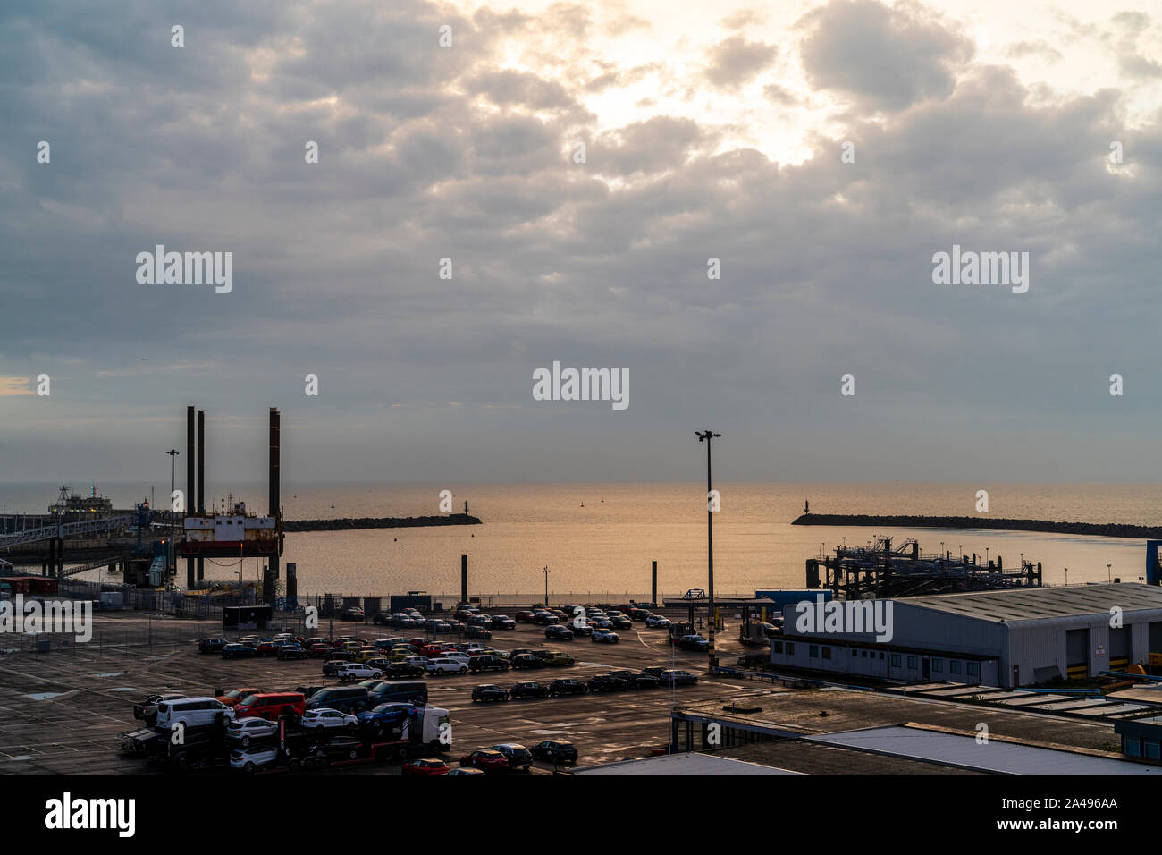 A cloudy dawn sky just after the sunrise hidden by the clouds over the mainly disused Ramsgate ferry port on the Kent Coast in England. Stock Photo