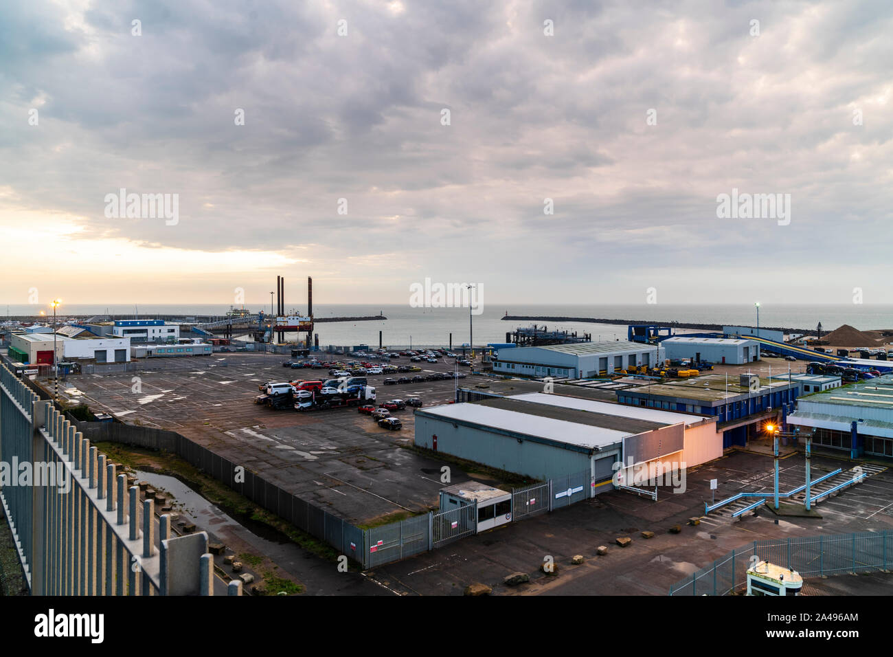 A cloudy dawn sky just after the sunrise hidden by the clouds over the mainly disused Ramsgate ferry port on the Kent Coast in England. Stock Photo