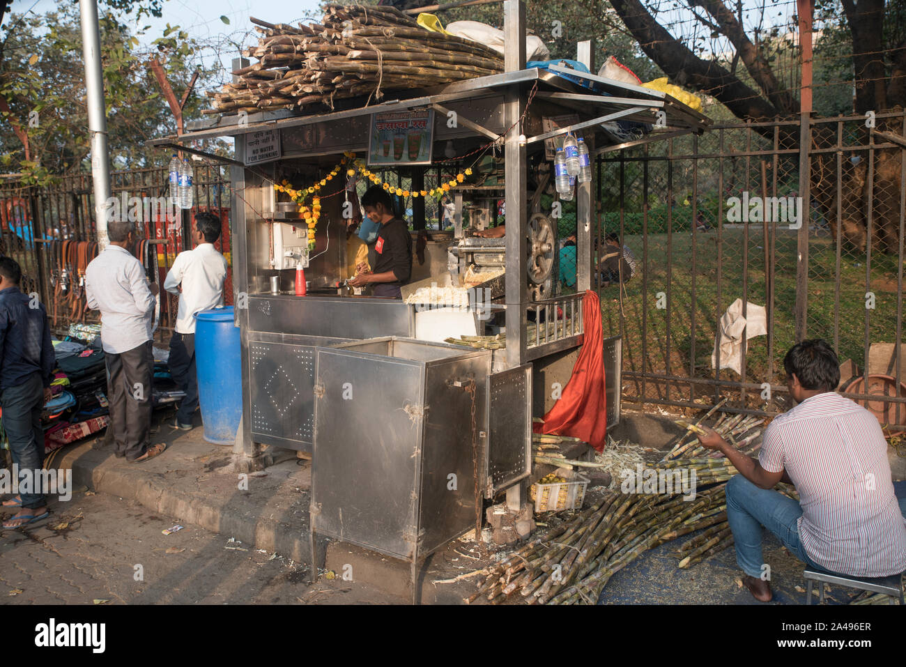 Workers at a sugarcane juice kiosk in Churchgate, Mumbai, India. Stock Photo