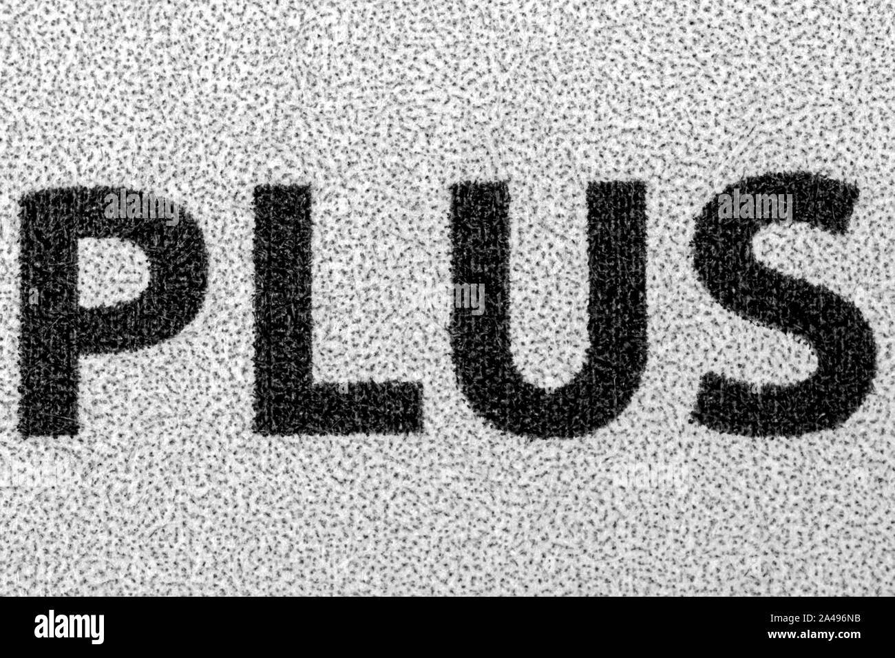 the word Plus written in capital letters on white background extreme close up Stock Photo