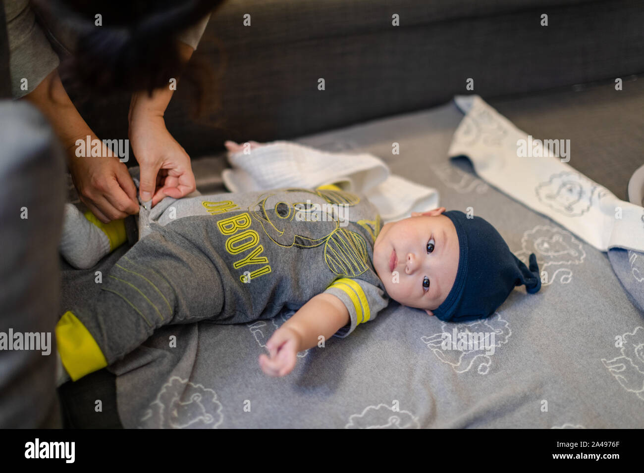 Baby changing clothes on sofa. child is 4 months old Stock Photo Alamy