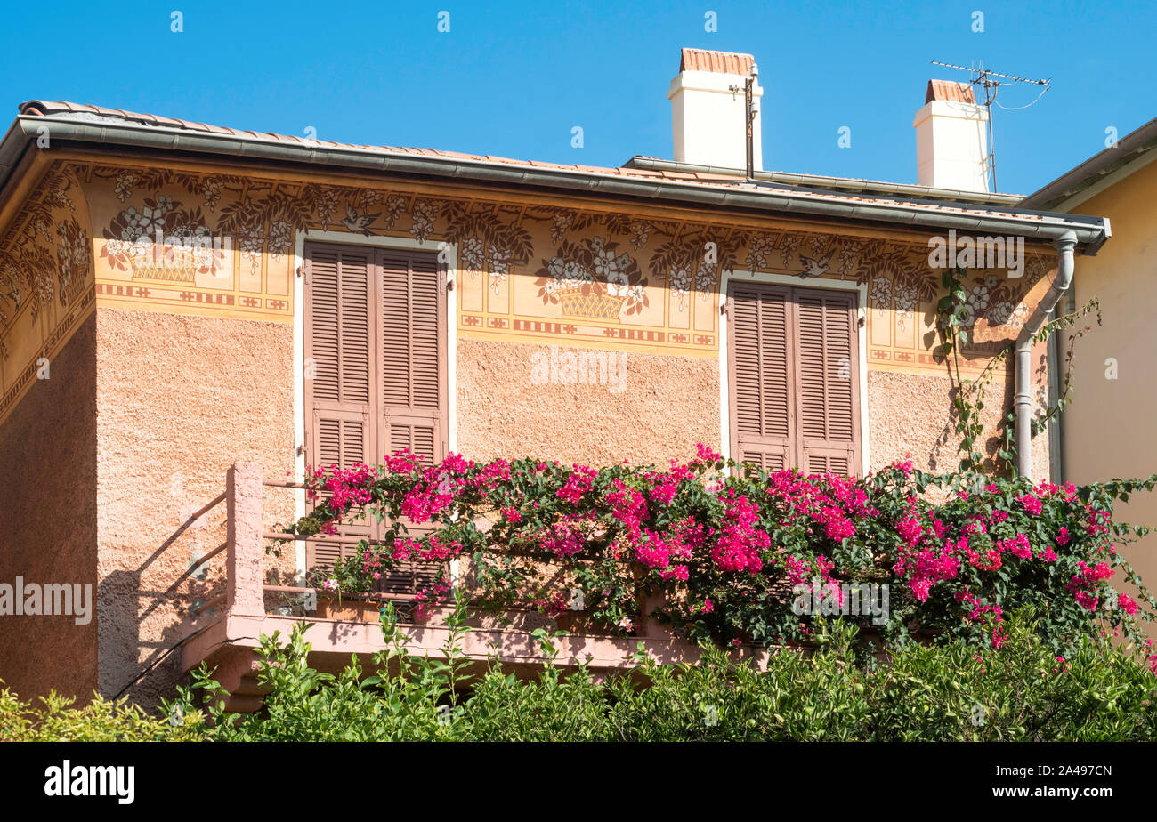 Ornately decorated house with red flowers trailing over balcony in Villefranche sur Mer, France, Europe Stock Photo