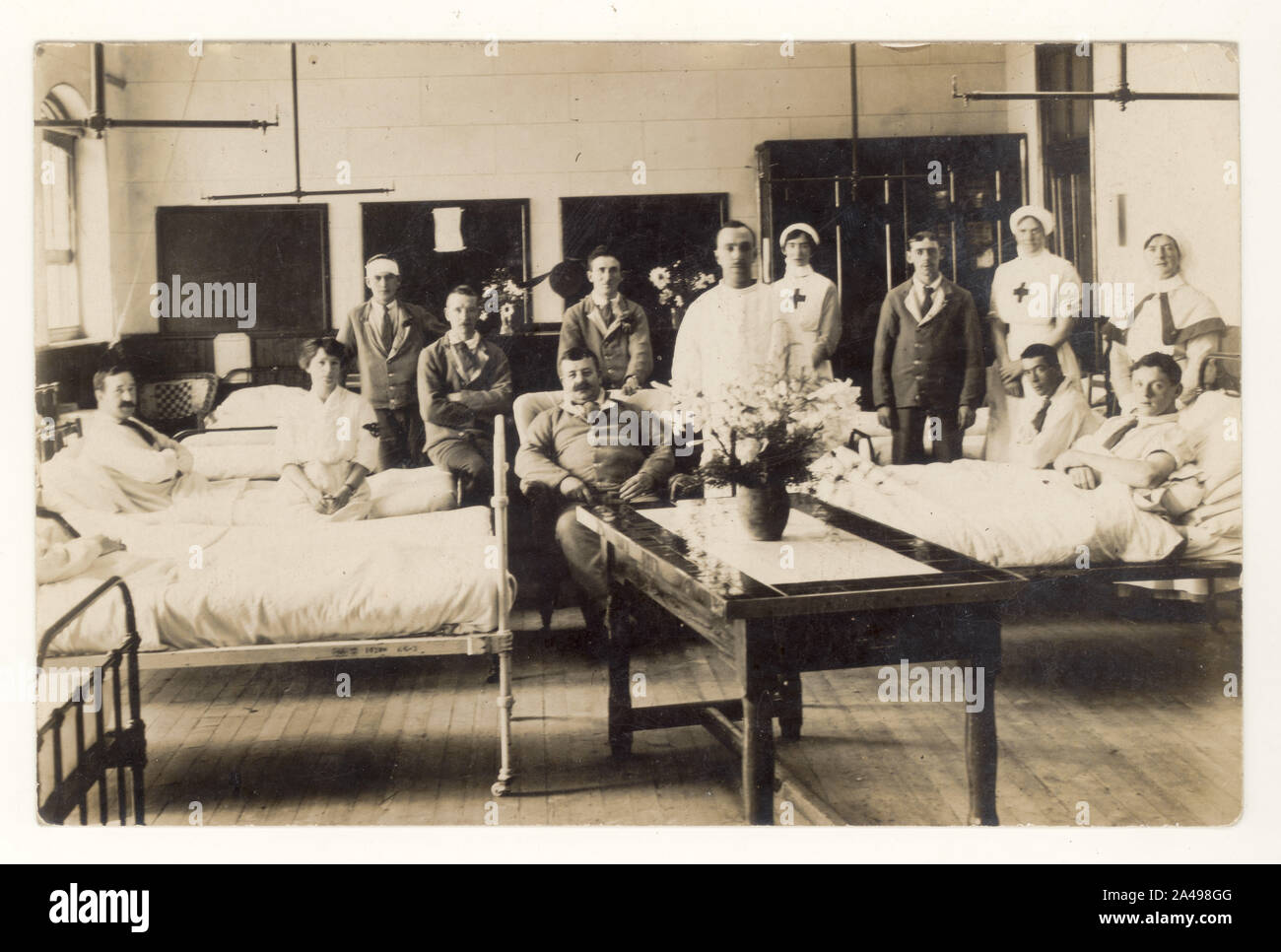WW1 era hospital ward with recovering British army soldiers, possibly auxiliary hospital for non life threatening injuries, cared for by red cross nurses, Voluntary Aid Detachment or VAD's , circa 1915, 1916, U.K. Stock Photo