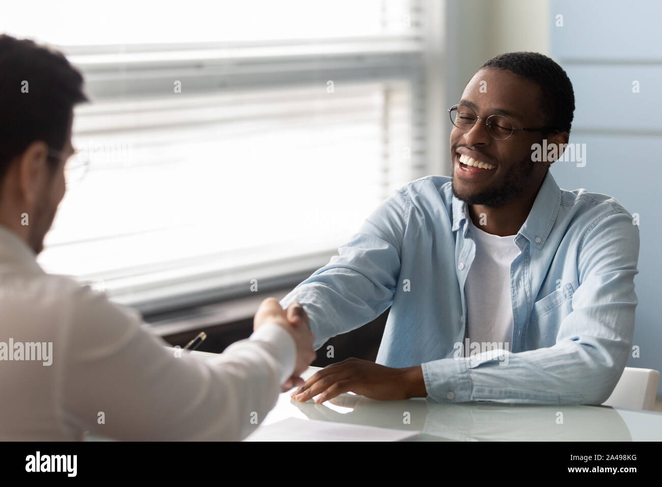 Happy african american job applicant shaking hands with hr manager