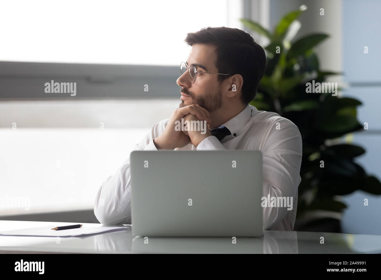 Distracted from job millennial businessman looking aside. Stock Photo