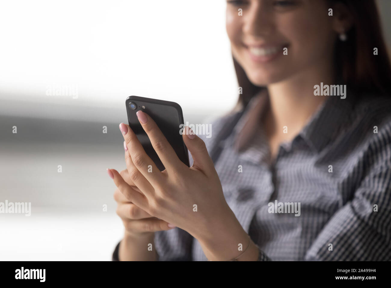 Close up happy young woman holding smartphone. Stock Photo
