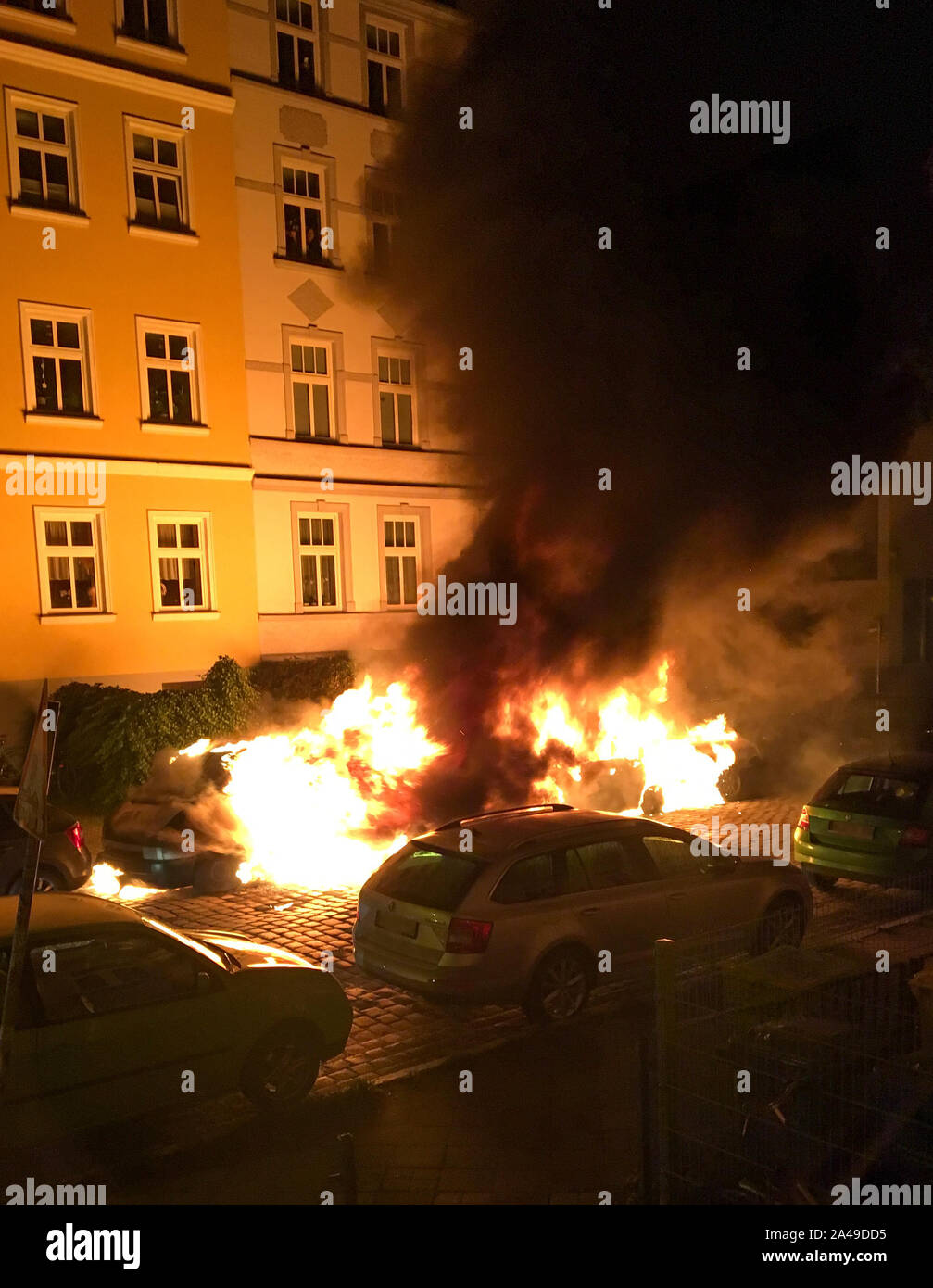 Rostock, Germany. 13th Oct, 2019. Three vehicles burn in a side street at the Unterwarnow. According to the police, four other vehicles were damaged in the fire on Sunday night. (to dpa 'Three cars in Rostock on fire - arson?') Credit: Mathilda Charisius/dpa/Alamy Live News Stock Photo