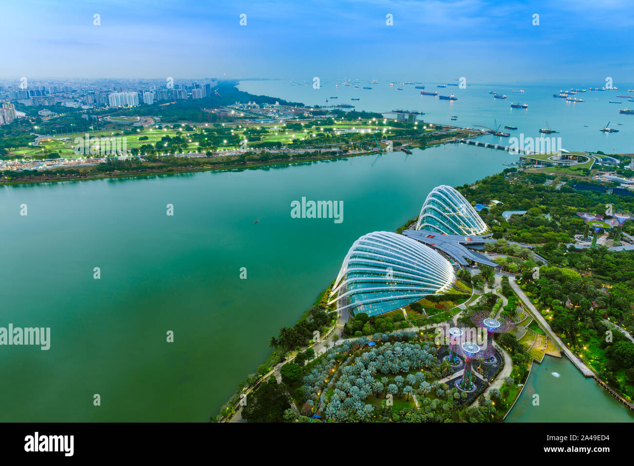 Singapore Gardens by the Bay botanical gardens aerial view and Marina Barrage dam with ship tankers in open sea. Stock Photo