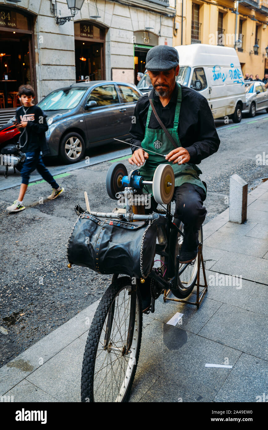 Madrid, Spain - Oct 13, 2019: Man sharpens knives using a bicycle on a street in Madrid, Spain Stock Photo