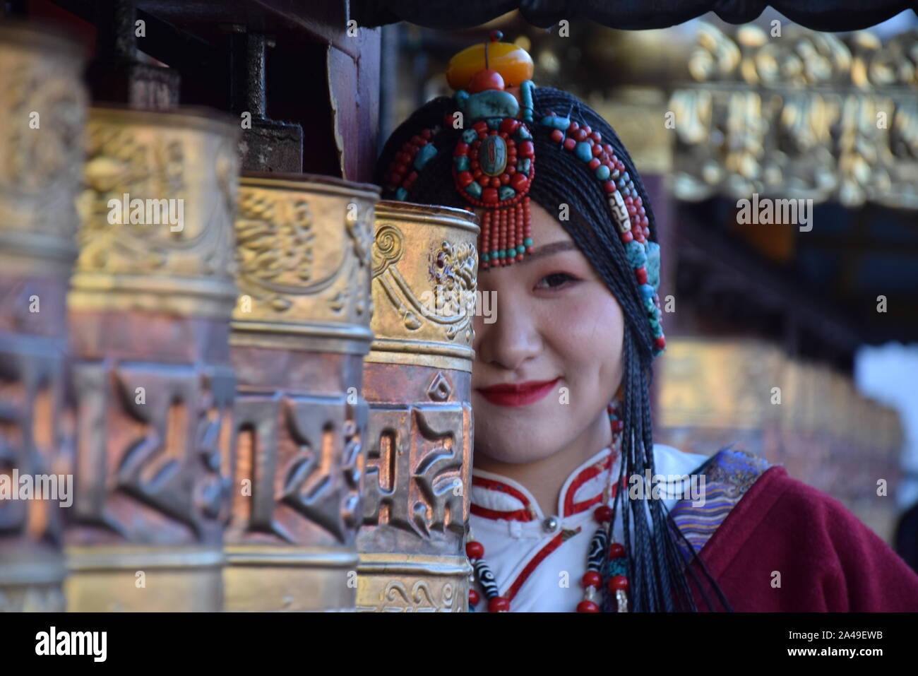 Beautiful asian girl taking photo shoot dressed with traditional tibetan clothes in Barkhor street, Lhasa - Tibet Stock Photo