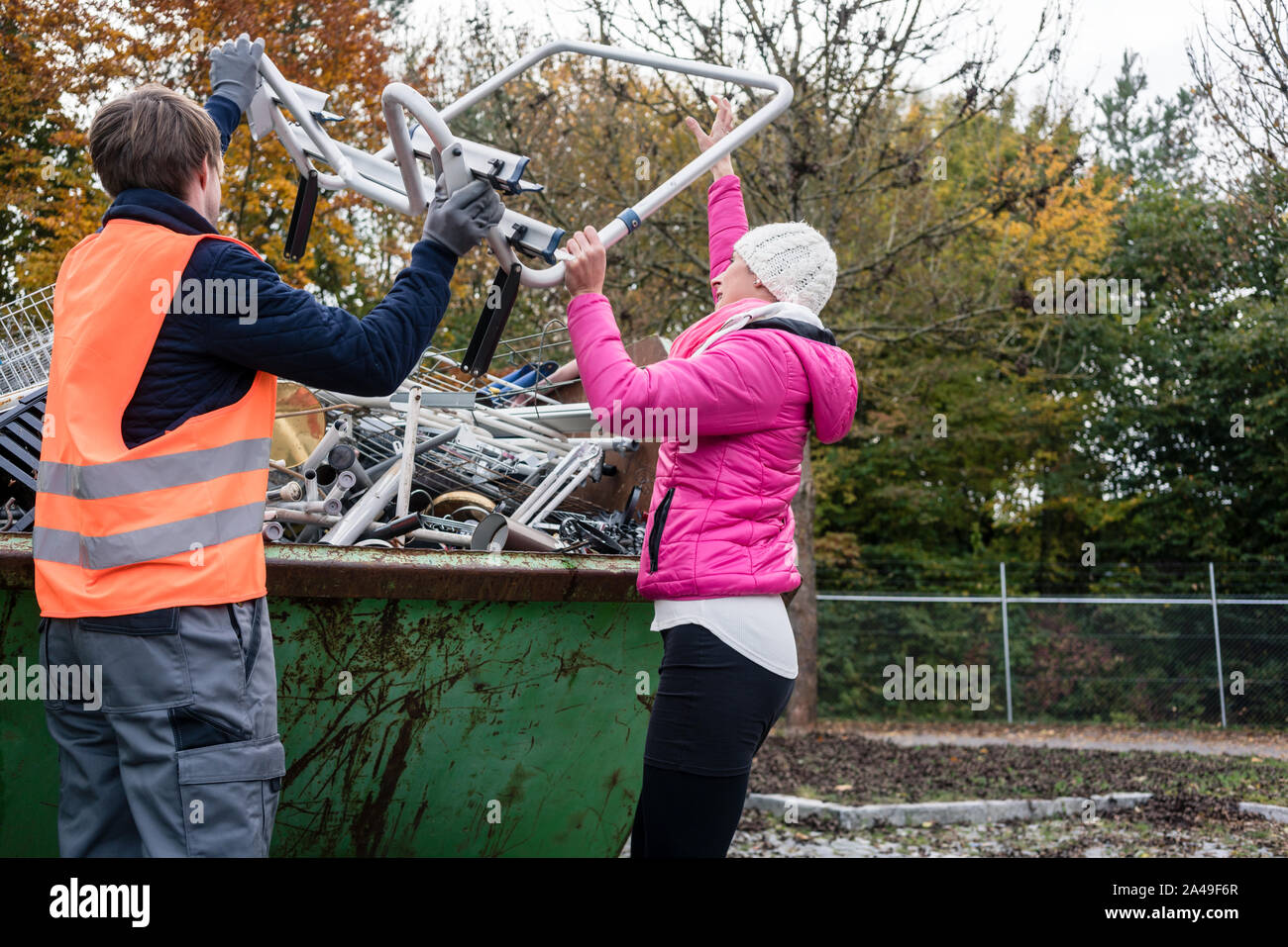 Woman putting scrap metal in container to be recycled Stock Photo