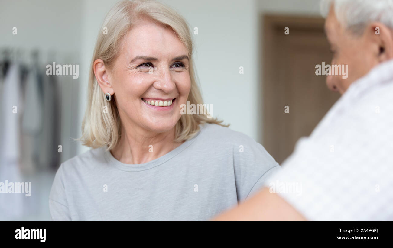 Focus on caregiver face female assisting patient listening older man Stock Photo