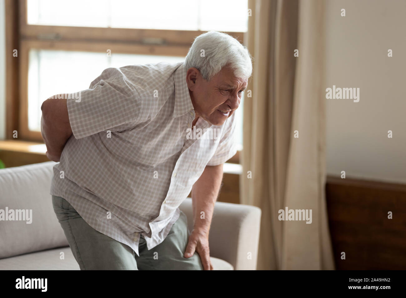Senior man got up from couch felt low back pain Stock Photo Alamy