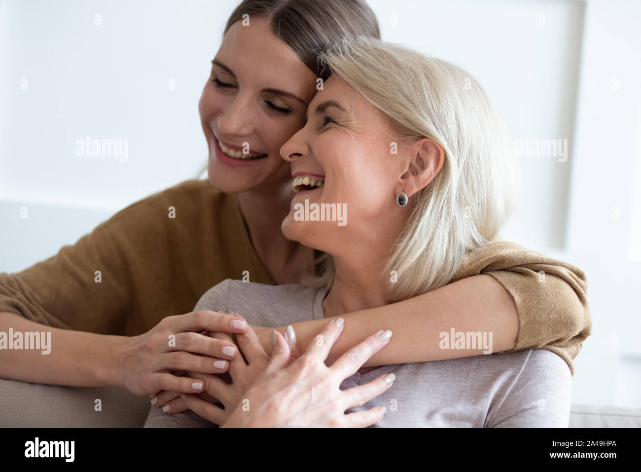 Closeup adult daughter hugs elderly mother enjoy tender moment Stock Photo
