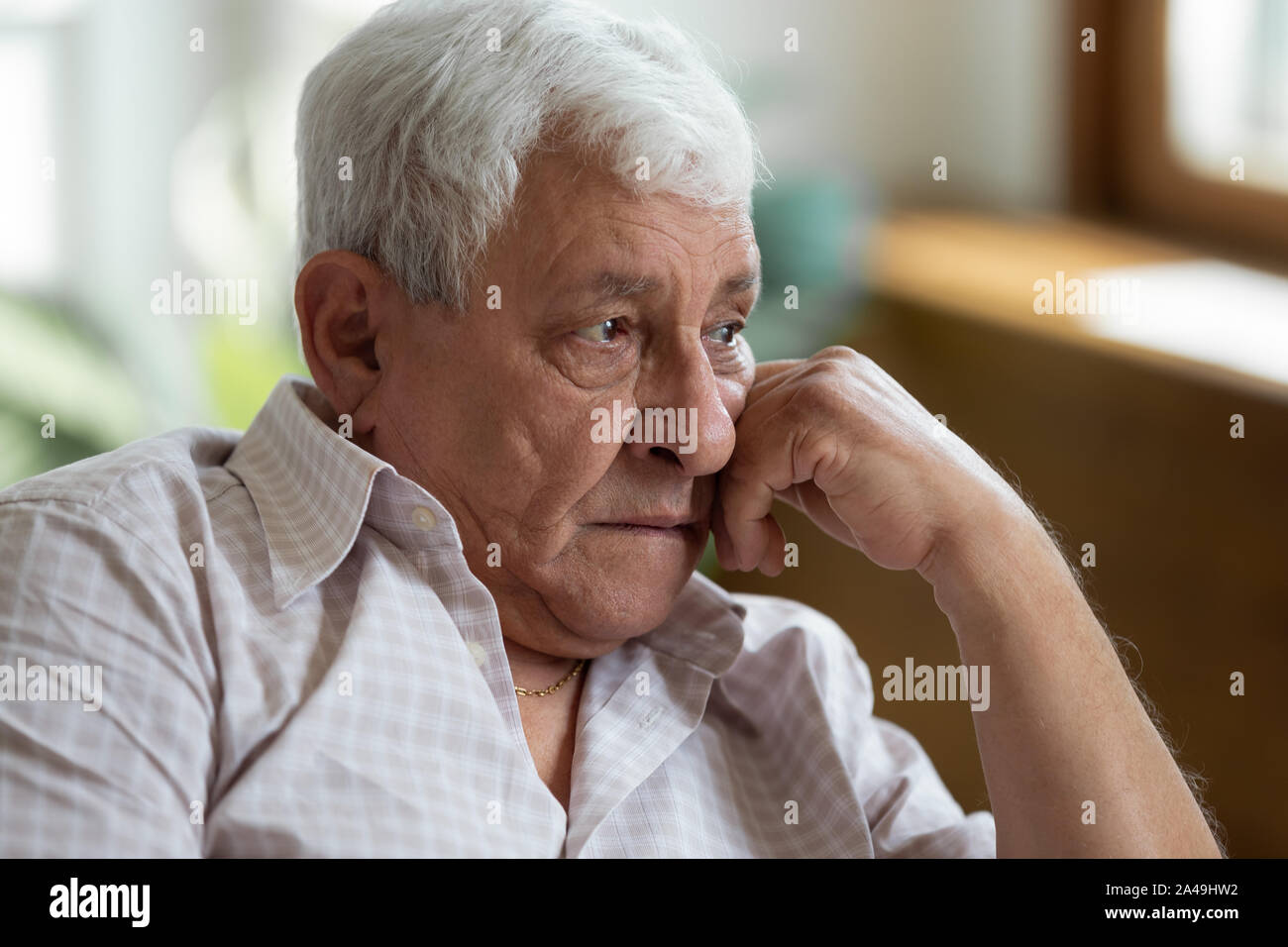 Sad grandfather put head on hand lost in thoughts Stock Photo