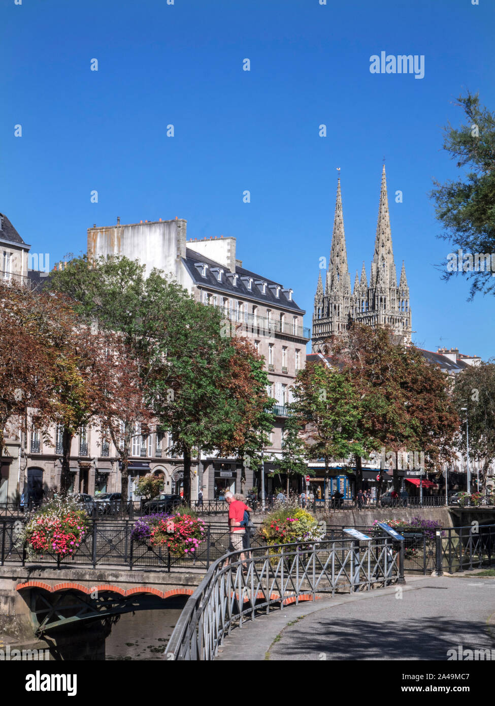 Quimper Town floral bridge and couple with River Odet & Gothic-style Quimper Cathedral Saint Corentin twin spires in background Quimper Brittany Stock Photo