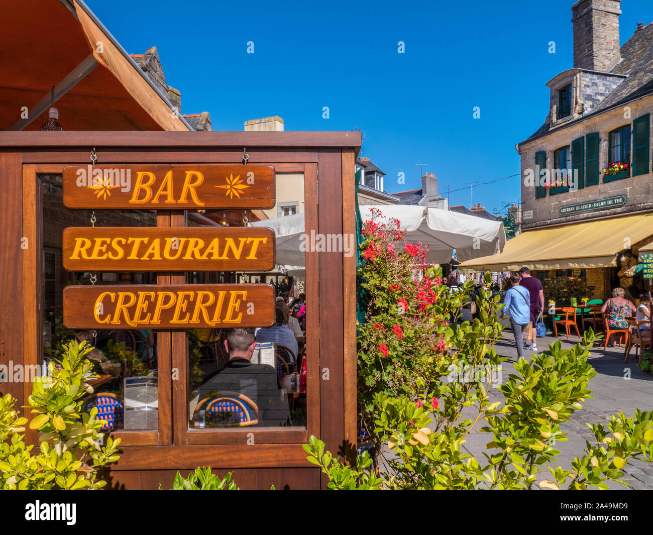 Old Concarneau Brittany French alfresco bar creperie restaurant sign with visitors enjoying sun Ville Close de Concarneau Bretagne Finistere France Stock Photo