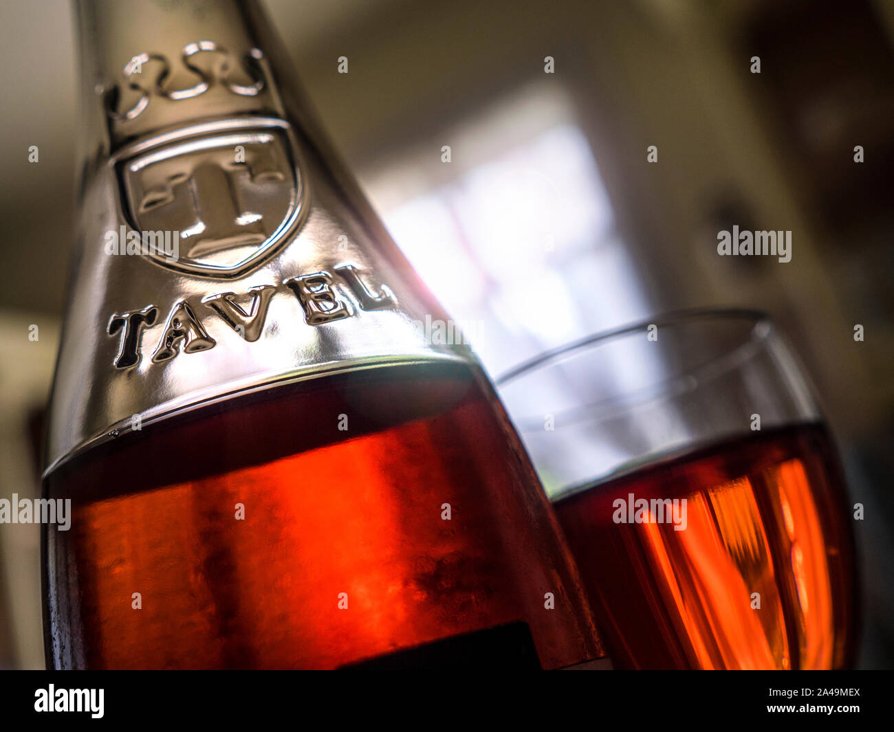 TAVEL ROSÉ Bottle and glass of Tavel rosé wine on French restaurant table with late afternoon light breaking through window Gard, Southern France Stock Photo