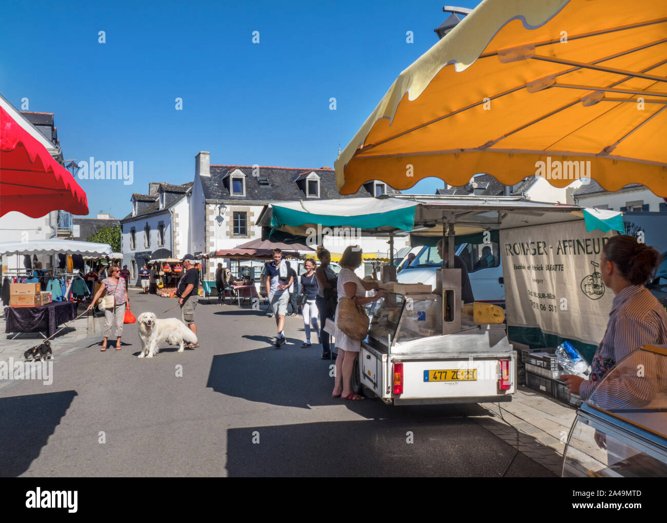 Breton Nevéz Brittany Street Market Charming French Breton weekly general market in church square selling local produce such as meats cheese clothing drinks basketware etc in Névez Brittany France Stock Photo