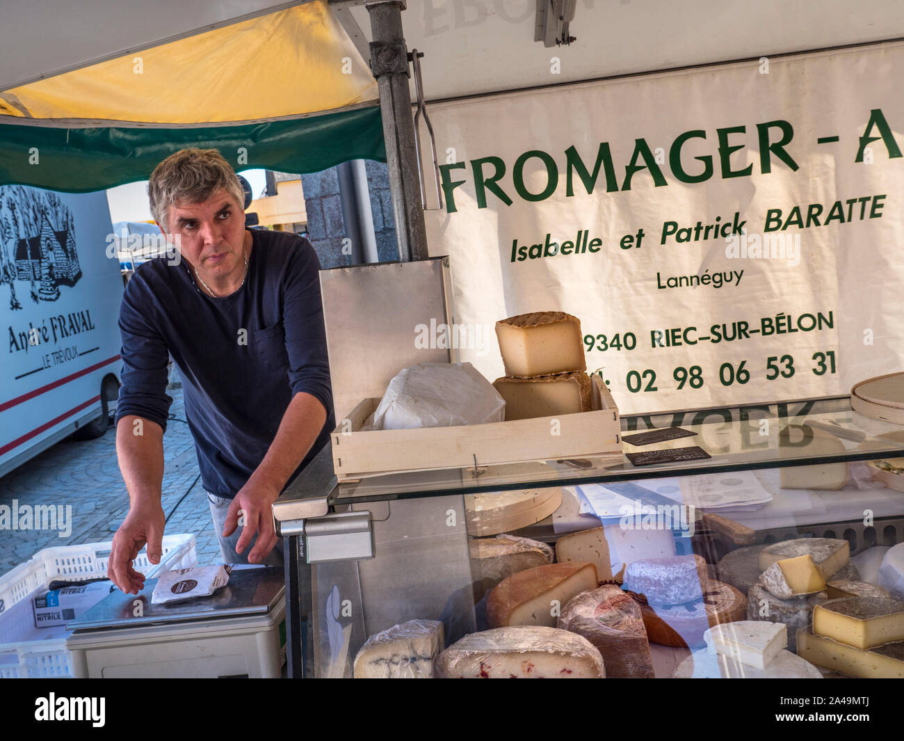 Breton Cheese market stall Brittany Street Market Fromager cheese maker market stall Charming French Breton weekly general market in church square selling local cheeses meats clothing drinks basketware etc in Névez Brittany France Stock Photo