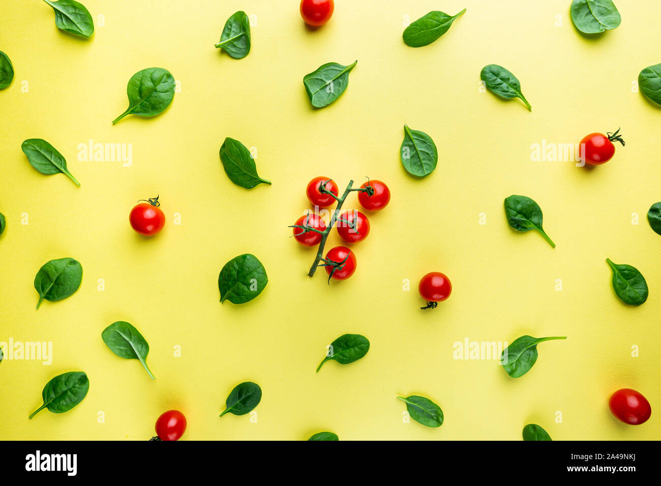 Spinach leaves and tomato pattern background on yellow, top view Stock ...
