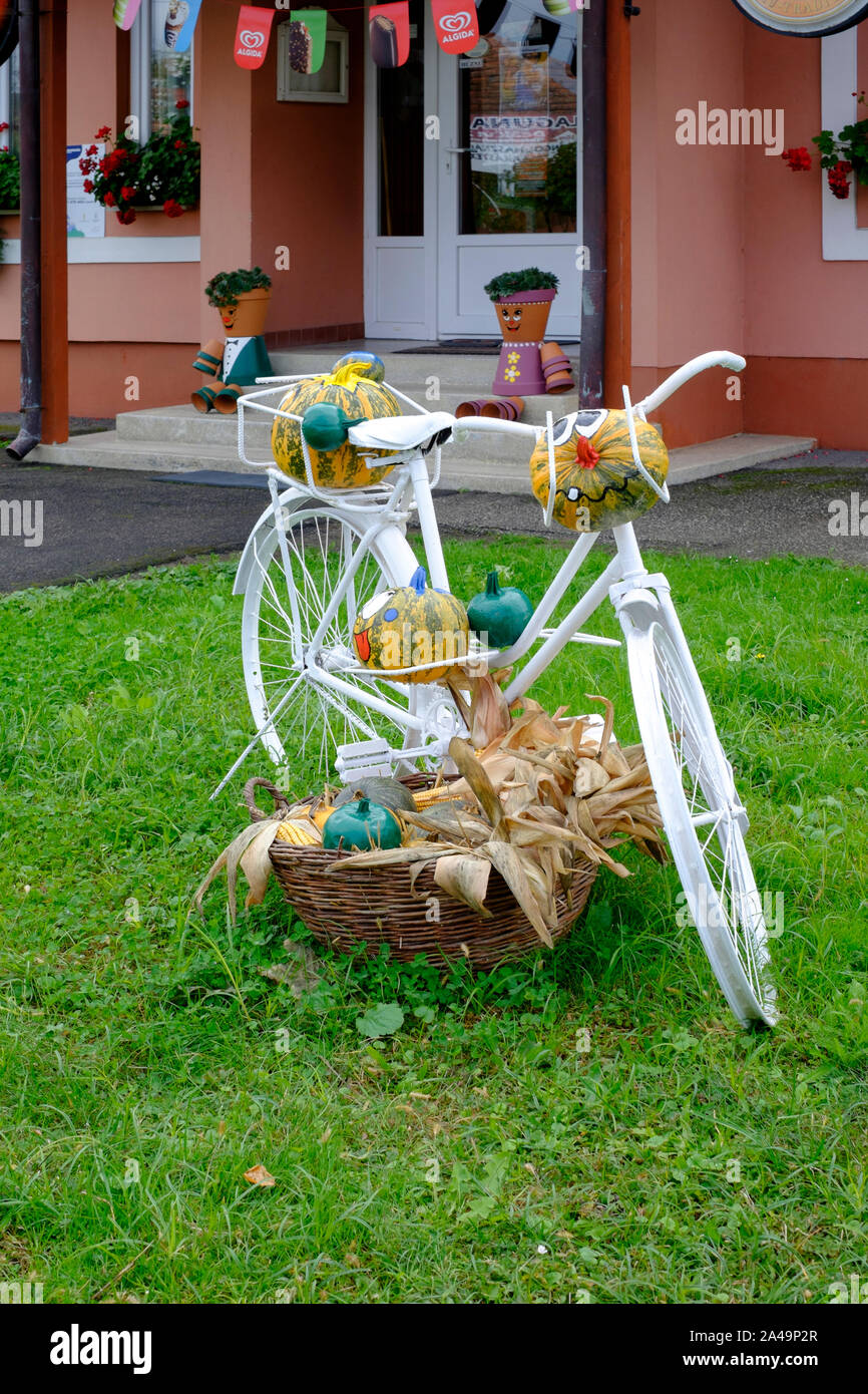 old style bicycle painted white and adorned with watermelons with smiling faces for halloween display lenti zala county hungary Stock Photo