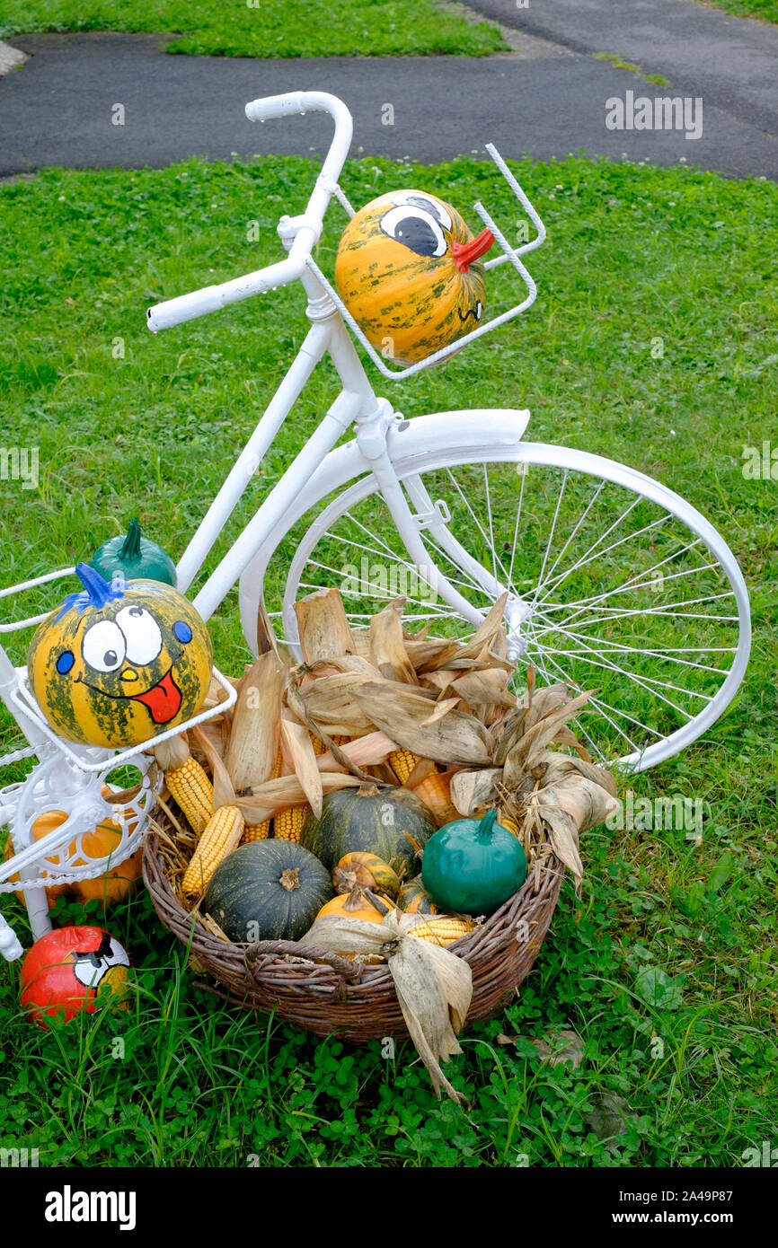 old style bicycle painted white and adorned with watermelons with smiling faces for halloween display lenti zala county hungary Stock Photo