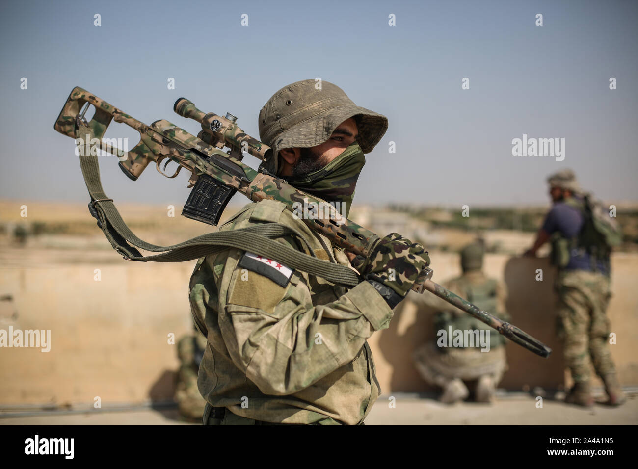 Tell Abiad, Syria. 13th Oct, 2019. A sniper from the Turkish-backed Syrian National Army satnds on a rooftop at Suluk town in the countryside of Tell Abiad after clashes with Kurdish fighters. Credit: Anas Alkharboutli/dpa/Alamy Live News Stock Photo