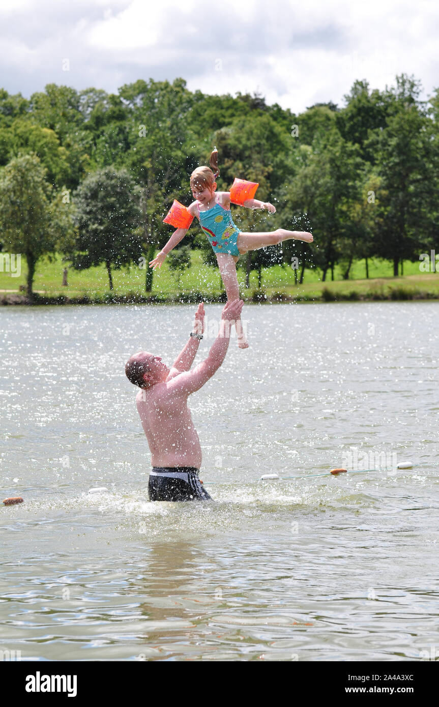 Child thrown in the air in lake by father Stock Photo Alamy