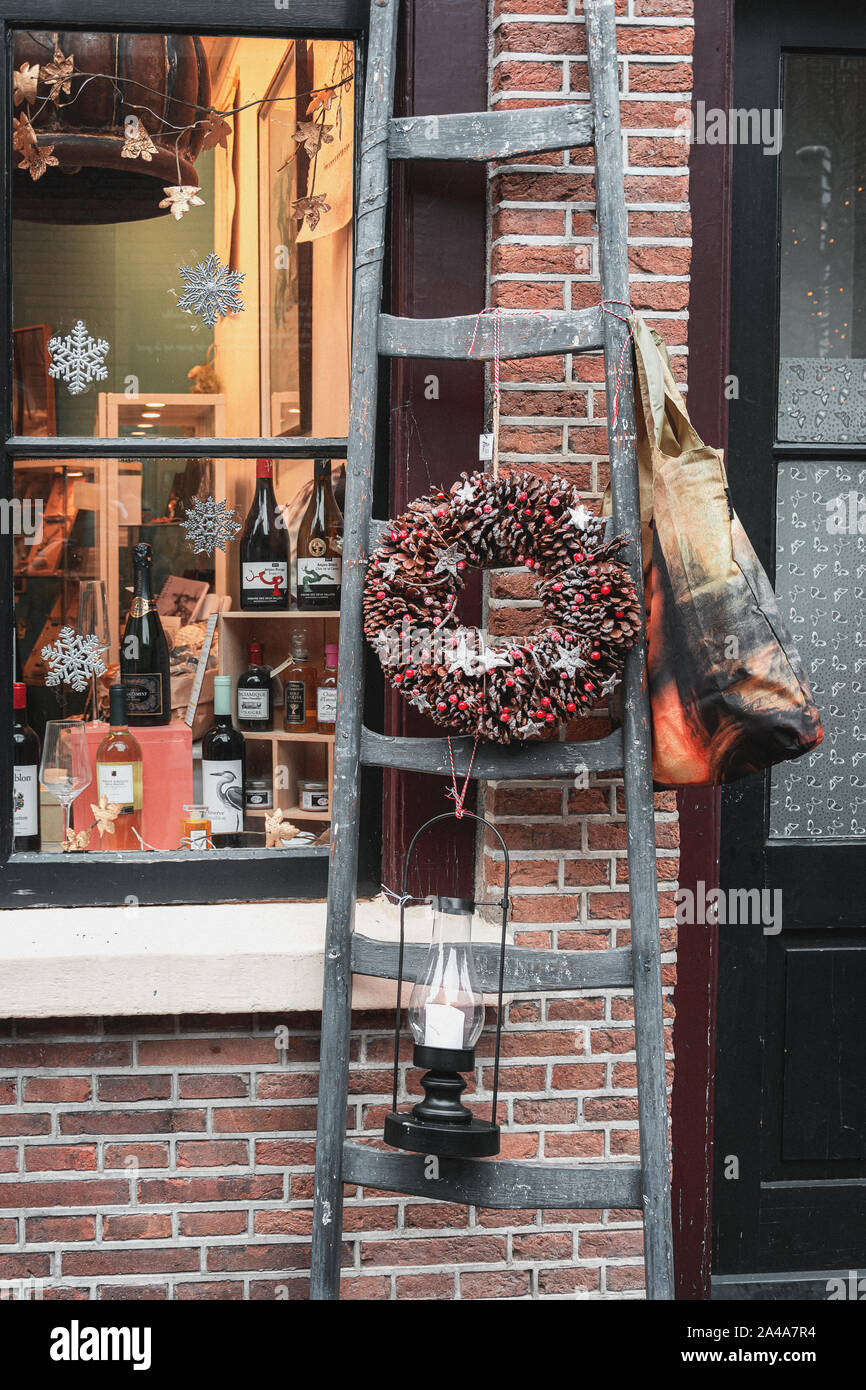Deventer, Netherlands - December 15, 2018: Ladder against the facade of a liquor store decorated with Christmas elements in Deventer. in The Netherlan Stock Photo